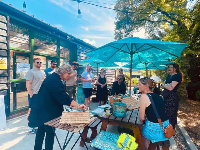 The team gathered round a picnic bench for a gin tasting under turquoise parasols.