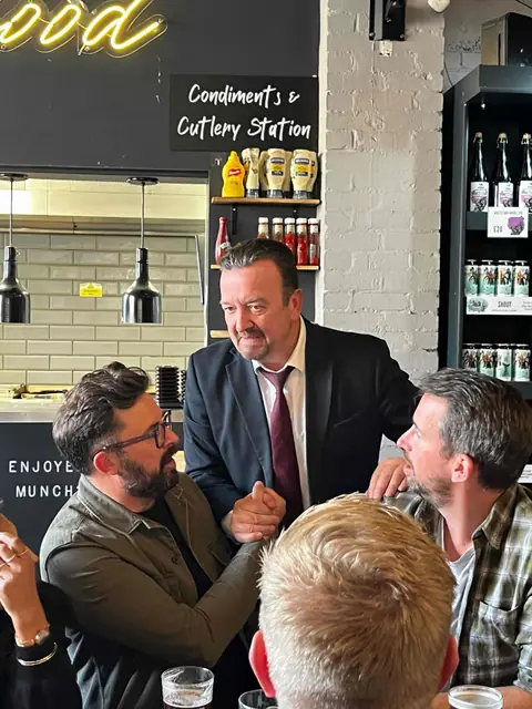 Team members chatting round a table at a pub lunch.