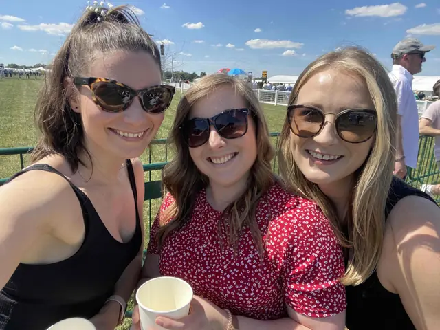 Three colleagues in sunglasses taking a selfie at the races.